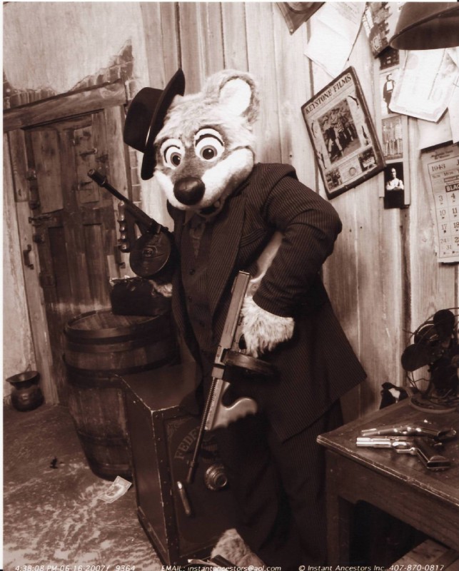 clothed clothing costume fedora fully_clothed fursuit gun handgun hat headgear headwear holding_gun holding_object holding_ranged_weapon holding_weapon looking_at_viewer mafia male ranged_weapon real smile solo submachine_gun suit text thompson_gun weapon unknown_artist twinkie mammal mustelid otter english_text hi_res monochrome sepia