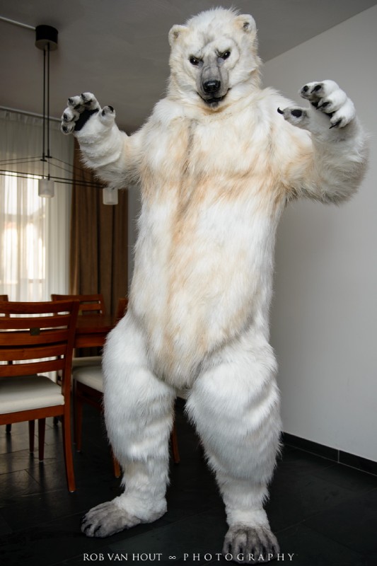 chair clothing costume furniture fursuit looking_at_viewer male pose real solo standing table text unknown_artist garrodor bear mammal polar_bear ursine 2014 grandfathered_content hi_res photography_(artwork)